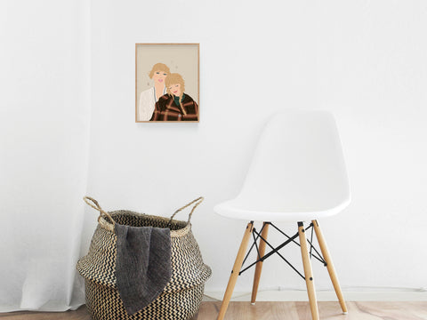 A minimalist room features a white chair, a woven basket with a gray blanket, and the Onderkast Studio TS Folkevermore Art Print framed on the wall, adding a cozy woodsy vibe inspired by folklore and evermore.