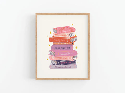 The Smut Book Stack Art Print by Onderkast Studio features a vibrant stack labeled “Fairy Smut,” “Holiday Smut,” and more—perfect decor for readers looking to add a spicy, bookish touch to their space.