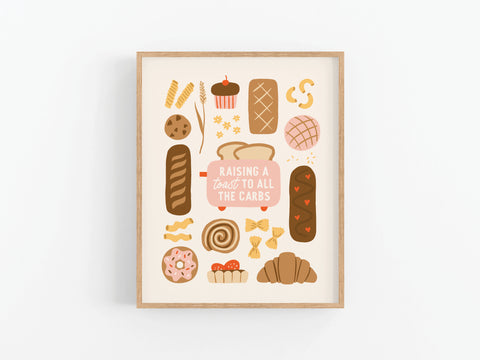The Toast to the Carbs Art Print by Onderkast Studio features bread and baked goods illustrations with Raising a toast to all the carbs in the center. This framed piece is perfect kitchen decor with a light background and wooden frame.