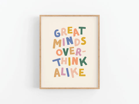 A framed Great Minds Overthink Alike Art Print by Onderkast Studio features vibrant colors and playful letters on a crisp white background—perfect for adding personality to your office or brightening up a clean white wall.