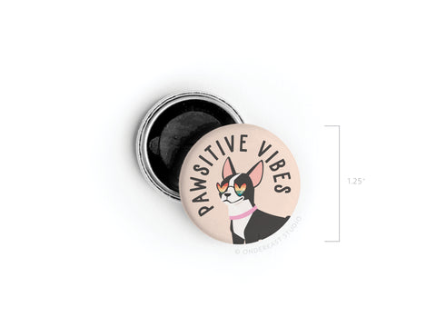 The Pawsitive Vibe Dog Button Magnet by Onderkast Studio features a smiling cat in glasses and a pink scarf with “PAWSITIVE VIBE” above. This cheerful 1.25 magnet pairs perfectly with our Frenchie Magnet or Dog Button Magnet.