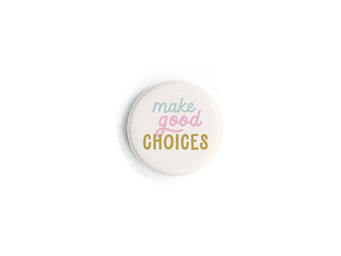 A stylish accessory from onderkast studio, the Make Good Choices Button Magnet showcases vibrant pastel blue, pink, and mustard yellow lettering on a white background.