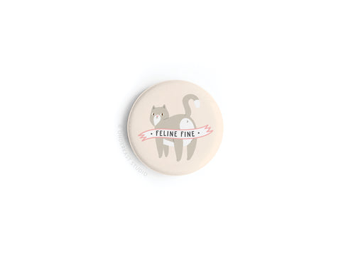 The Onderkast Studio Feline Fine Cat Button Magnet features a chic cat silhouette with its tail up and “FELINE FINE” in pink on an off-white background—a stylish feline enthusiast accessory.