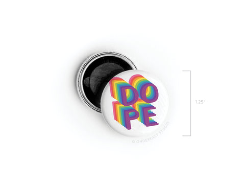 The DOPE Button Magnet by Onderkast Studio features bold, colorful 3D letters with rainbow shadows on a white 1.25-inch base and a visible open pinback for extra detail. A stylish, high-quality magnet for any space.