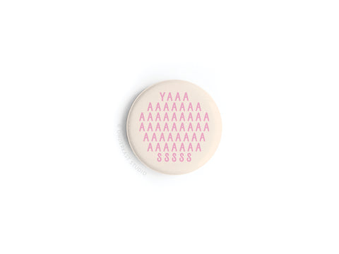 The YASS Pink Button Magnet by Onderkast Studio features bright pink capitals on beige, highlighting quality craftsmanship. Discontinued.