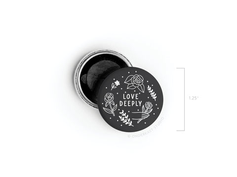 A small 1.25” round Love Deeply Button Magnet by onderkast studio, now discontinued, features a black lid with white floral designs and the phrase LOVE DEEPLY at the center, showcasing its high-quality craftsmanship.