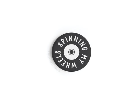 The Smagnetning My Wheels Button Magnet by Onderkast Studio features a black and white vinyl record design with “SPINNING MY WHEELS” around the edge, produced in high-quality, now discontinued.