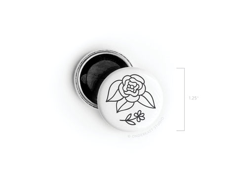 The Onderkast Studio Black Flowers Button Magnet is a 1.25-inch round pinback magnet featuring a black outline floral design on white, shown with its open black backing.