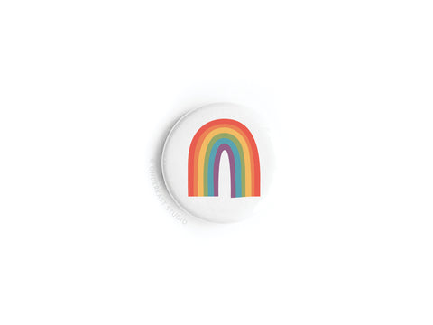 The Onderkast Studio Pride Rainbow Button Magnet is a round white magnet with a simple six-color rainbow flag design, perfect for celebrating LGBTQ+ equality.