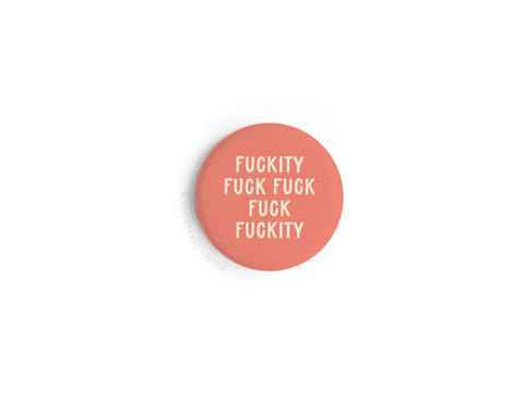 The Onderkast Studio Fuckity Fuck Fuck Fuck Fuckity Button Magnet is a round, coral-colored magnet with bold white profanity in all-caps, featuring vibrant printing that stands out against a white background.