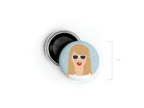 The TS 1989 Button Magnet by Onderkast Studio features an illustrated woman with blonde hair, white sunglasses, and red lipstick on a light blue background. Measures 1.25 in diameter.