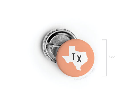 The Orange TX Pinback Button by Onderkast Studio is a 1.25-inch round accessory featuring a white Texas outline with TX at the center—an ideal way to show off your Texan pride in style.