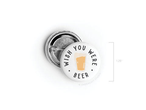 The Wish You Were Beer Pinback Button by Onderkast Studio features a vibrant beer glass design with the phrase “WISH YOU WERE BEER.” This 1.25-inch button makes a nostalgic gift for beer lovers.