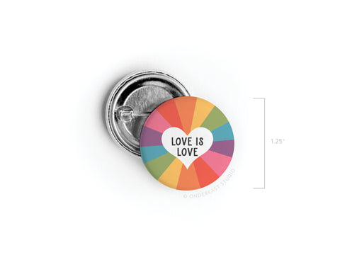 The Love Is Love Pinback Button by onderkast studio features a vibrant rainbow design with a white heart and “LOVE IS LOVE” text. This 1.25-inch round button celebrates universal love and is shown front and back in high quality.