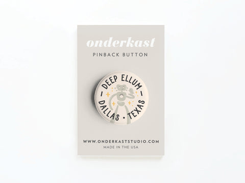 The Deep Ellum Travelling Man Pinback Button by Onderkast Studio features Deep Ellum Dallas, a guitar, stars, and Travelling Man art on a card with www.onderkaststudio.com and MADE IN THE USA.