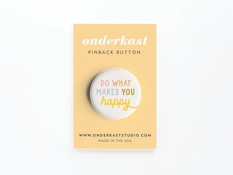 The Do What Makes You Happy Pinback Button by Onderkast Studio features colorful text on a yellow card, includes branding and website details, and spreads positivity with its high-quality design.