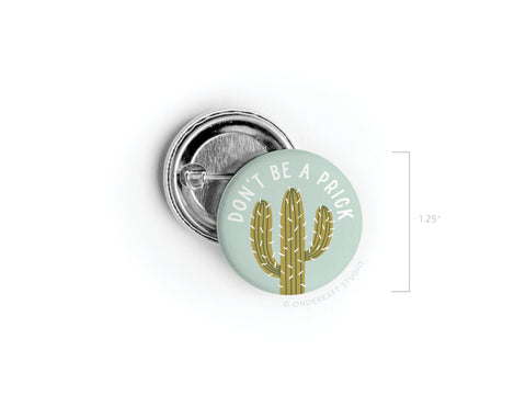 The Don’t Be a Prick Pinback Button by Onderkast Studio features a cactus design and bold white text. Made with high-quality materials, it measures 1.25 inches in diameter.
