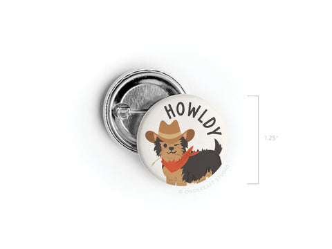 The Howldy Pinback Button by Onderkast Studio features a cute illustrated dog in a cowboy hat and red bandana, with HOWLDY above the pup. This 1.25-inch Western-themed accessory is perfect for adding charm to any outfit.