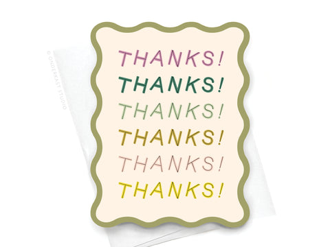 The Thanks Wavy Die Cut Notecard by Onderkast Studio features THANKS! six times in colorful fonts on a cream background with a green border, paired with a white envelope—perfect for stylishly expressing gratitude.