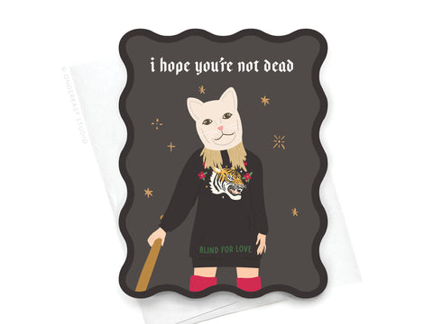 The TS Reputation Wavy Die Cut Notecard by Onderkast Studio features an illustrated person in a LWYMMD cat mask and sweater with BLIND FOR LOVE, surrounded by sparkles and the phrase i hope you’re not dead on a dark background.