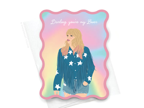 The TS Lover Wavy Die Cut Notecard by Onderkast Studio features an illustrated woman in a blue fringe jacket, denim shorts, and a pastel rainbow background with “Darling, you’re my Lover” in white script.