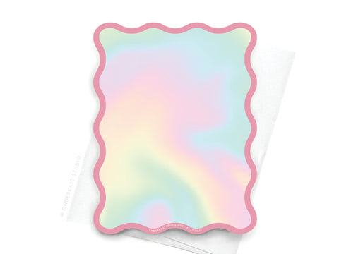 The TS Lover Wavy Die Cut Notecard by Onderkast Studio features a pastel, iridescent design with pink borders and soft gradients of pink, blue, yellow, and green—perfect for jotting down lyrics from Taylor’s iconic song.