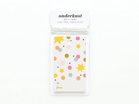 A set of 6 Confetti Gift Tags from Onderkast Studio with a colorful polka dot and starburst design, printed in the USA on sturdy card stock. Each tag has to/from fields and comes with white string.