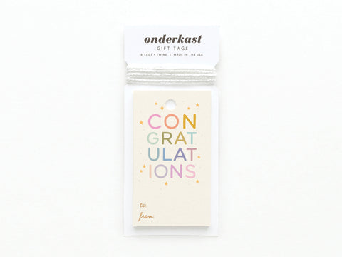 The Colorful Congratulations Gift Tag by Onderkast Studio is printed in the USA with colorful letters and stars, features to: and from: at the bottom, a white string at the top, and packaging reading onderkast GIFT TAGS.