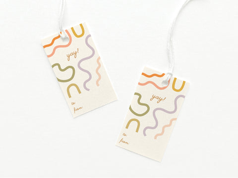 The Yay Squiggles Gift Tag by Onderkast Studio features abstract wavy lines in vivid colors and yay! on premium card stock, includes to/from sections, and comes with white string—perfect for stylish gifting.