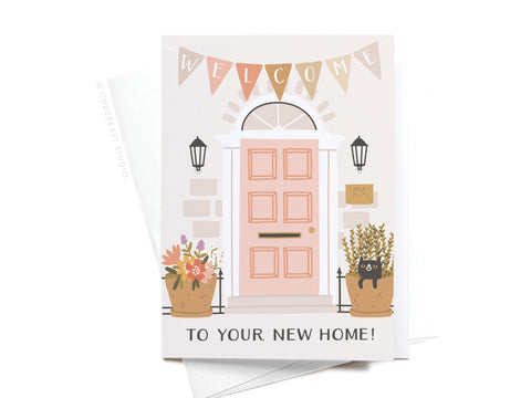 The Onderkast Studio Welcome to Your New Home Door Folded Greeting Note Set of 10 features a pink door, welcome bunting, two flower pots, a black cat, and To Your New Home! on premium card stock with white envelopes.