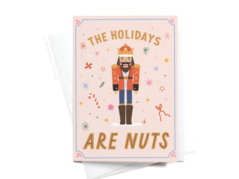 The Holidays Are Nuts Nutcracker Folded Greeting Note Set of 10 by Onderkast Studio features a nutcracker with confetti, candy canes, and stars. Vibrant colors and the cheerful message The holidays are nuts make it perfect for festive greetings.