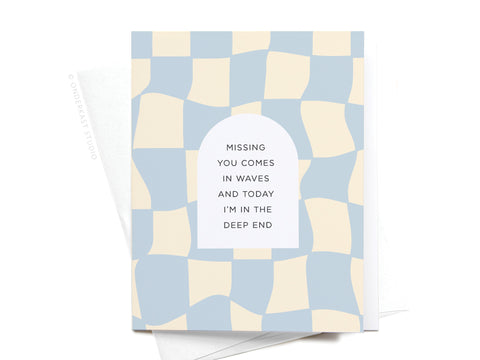 The Missing You Comes In Waves Greeting Card by Onderkast Studio features a pale blue and cream wavy checker pattern with the message Missing You Comes In Waves and today I’m in the deep end. Includes premium envelope.