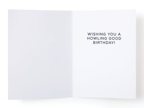 The Woo! Birthday Dogs Greeting Card by Onderkast Studio features bold black text, Wishing you a howling good birthday! on the right and a blank left side—an ideal choice for dog lovers and fans of cute dog illustrations.