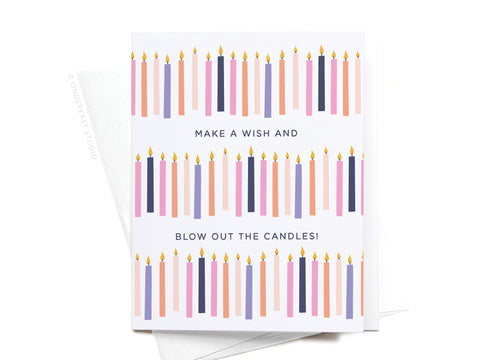 The Make a Wish and Blow Out the Candles Greeting Card by Onderkast Studio features rows of colorful lit candles and the message MAKE A WISH AND BLOW OUT THE CANDLES! Photographed atop a white envelope.