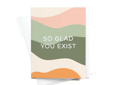 The So Glad You Exist Greeting Card by Onderkast Studio features wavy pastel peach, green, and cream bands with SO GLAD YOU EXIST in bold white letters for a premium feel.
