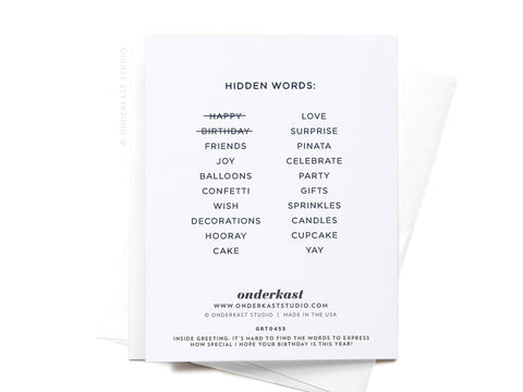 The Onderkast Studio Happy Birthday Word Search Greeting Card features hidden words like friends, balloons, wish, cake, and gifts; happy and birthday are crossed out. The card is shown with a white envelope.