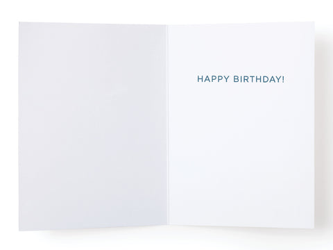 The Shark Fin Party Hats Birthday Greeting Card by Onderkast Studio features a blank left side and HAPPY BIRTHDAY! in blue on the right—a simple, minimalistic card with a humorous shark fin party hat design for any birthday.
