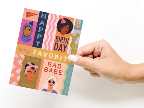 A hand holds Onderkast Studios Happy Birthday to My Favorite Bad Babe card, featuring diverse illustrated women and empowering birthday wishes—perfect for celebrating the strong feminist in your life.