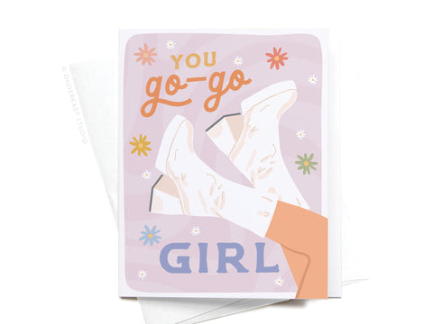 Celebrate achievements with Onderkast Studio’s You Go-Go Girl Greeting Card, featuring white go-go boots and “You go-go girl” text surrounded by colorful flowers on a pastel background—a perfect encouragement card for any occasion.