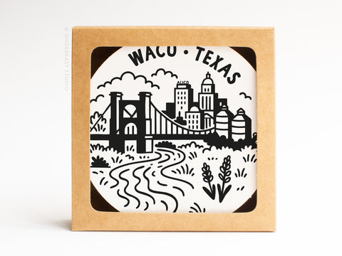 The Waco Texas Skyline Letterpress Coaster Set by Onderkast Studio features black-and-white cityscape illustrations, including a bridge, river, buildings, silos, and plants with WACO • TEXAS at the top, packaged in a cardboard box.