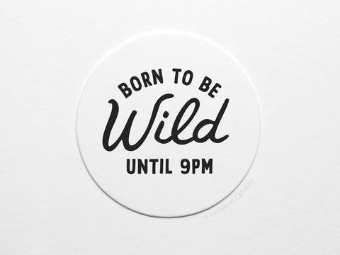 The Born To Be Wild Until 9pm Letterpress Coaster Set by Onderkast Studio features white circle coasters with black text, perfect for a fun set. Comes packaged in a recyclable kraft box.