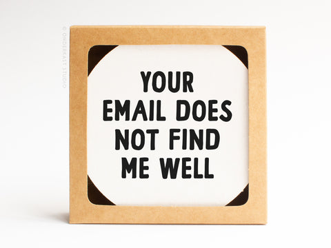 The Your Email Does Not Find Me Well Letterpress Coaster Set by Onderkast Studio features square coasters in brown frames with bold black text on white, making a witty, modern addition to any coaster collection.