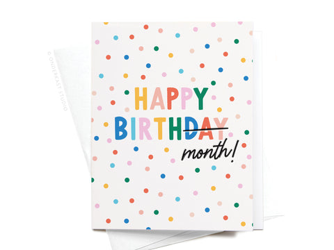 Onderkast Studio’s Happy Birth-month Letterpress Greeting Card features colorful polka dots and “HAPPY BIRTHDAY,” with “BIRTHDAY” crossed out and replaced by “month!” in black script. Includes a white envelope.