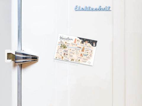 A white refrigerator displays an Onderkast Studio Houston Map Refrigerator Magnet near the top and features a Texas souvenir postcard reading Houston, Texas on the door. The handle is visible on the left side.