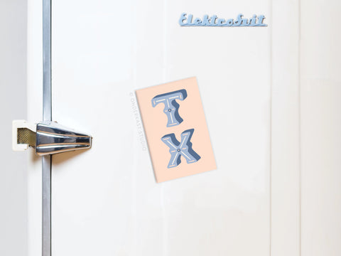 A retro white fridge with a silver handle features an Onderkast Studio TX Refrigerator Magnet and Elektrobut in blue script, adding bold charm to the minimal design.