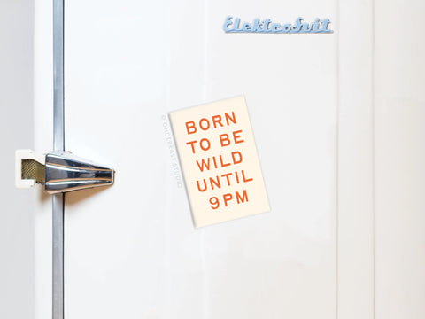 A white fridge with a silver handle and Elektronlit label features the Onderkast Studio Born To Be Wild Refrigerator Magnet, showcasing BORN TO BE WILD UNTIL 9PM in vibrant orange letters on the door.