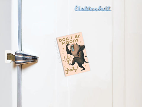 The Shake Ya Booty Baboon Refrigerator Magnet by Onderkast Studio, featuring a baboon and the phrase DONT BE MOODY, shake ya Booty!, decorates the fridge, with Elektrosvit displayed in the upper right corner.