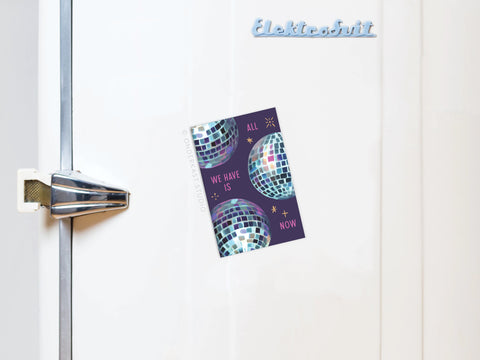A white retro refrigerator with a metal handle and an Elektrosvit label is adorned with the Onderkast Studio All We Have Is Now Disco Balls Refrigerator Magnet, featuring a colorful philosophical message.