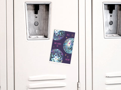 An Onderkast Studio All We Have Is Now Disco Balls refrigerator magnet with a retro design and philosophical message is attached to a white metal locker.