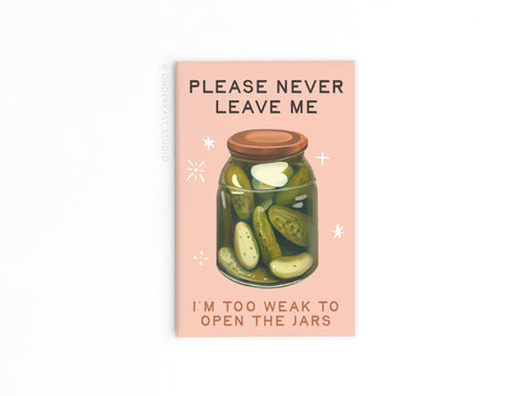 The Never Leave Me Pickles Jar Refrigerator Magnet by Onderkast Studio features a jar of pickles with the phrases “Please never leave me” and “I’m too weak to open the jars”—a fun gift for any pickle lover!.